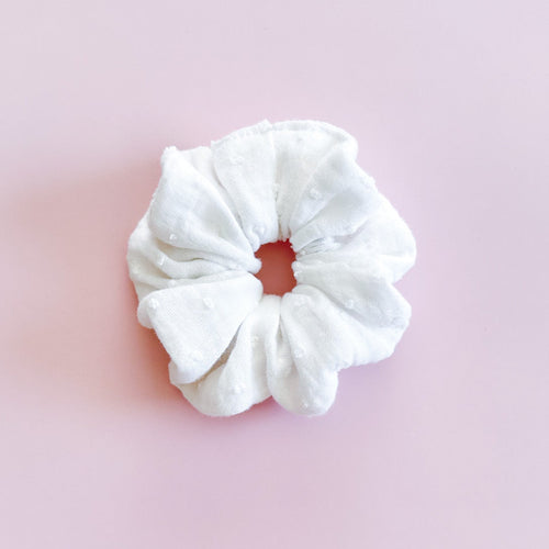 Chouchou cheveux Chloé en gaze de coton blanc plumetis de fabrication artisanale, présenté à plat sur fond rose.