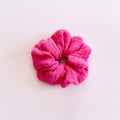 Chouchou pour cheveux en gaze de coton rose fuchsia de fabrication artisanale, présenté à plat.
