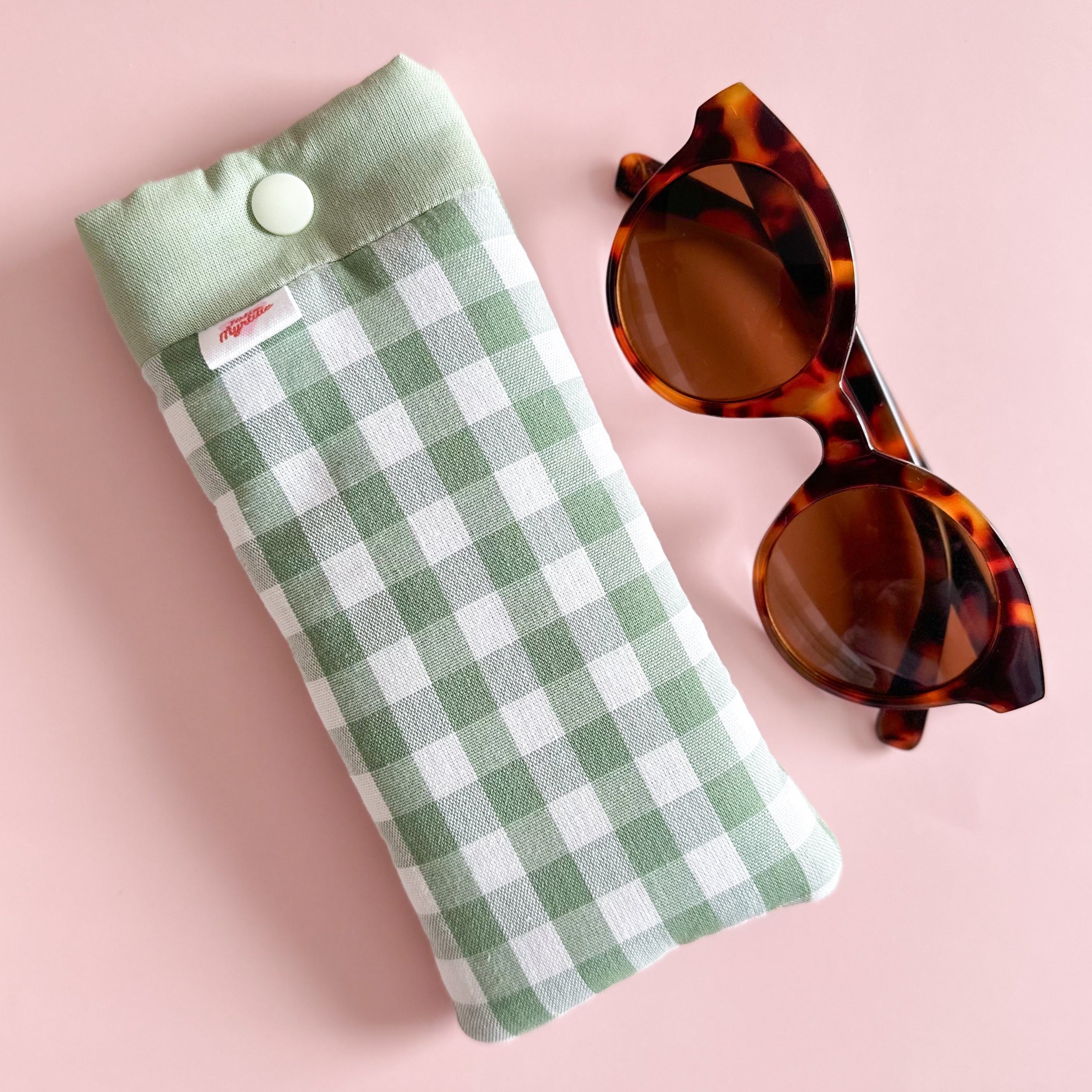 Etuis à lunettes vichy vert sauge cousu main avec lunettes de soleil fond rose clair