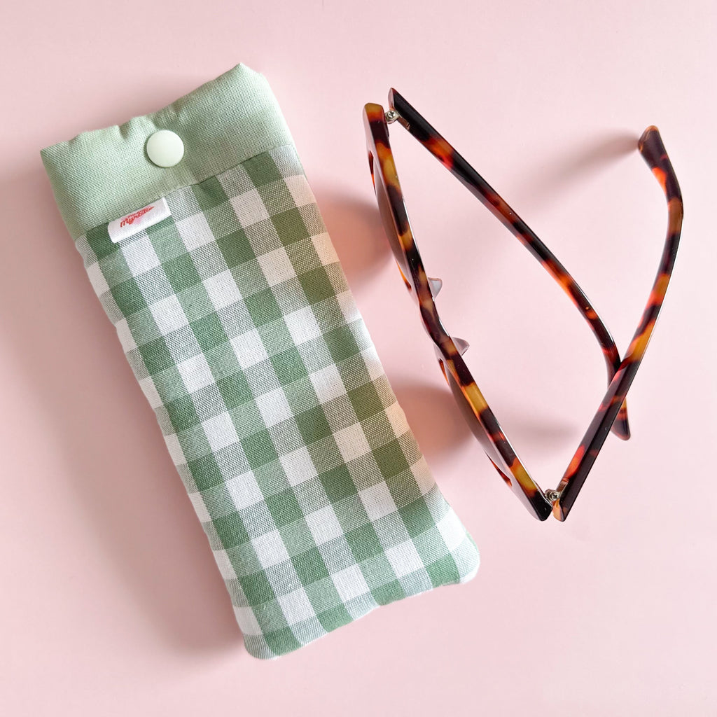 Etuis à lunettes vichy vert sauge cousu main avec lunettes de soleil fond rose clair