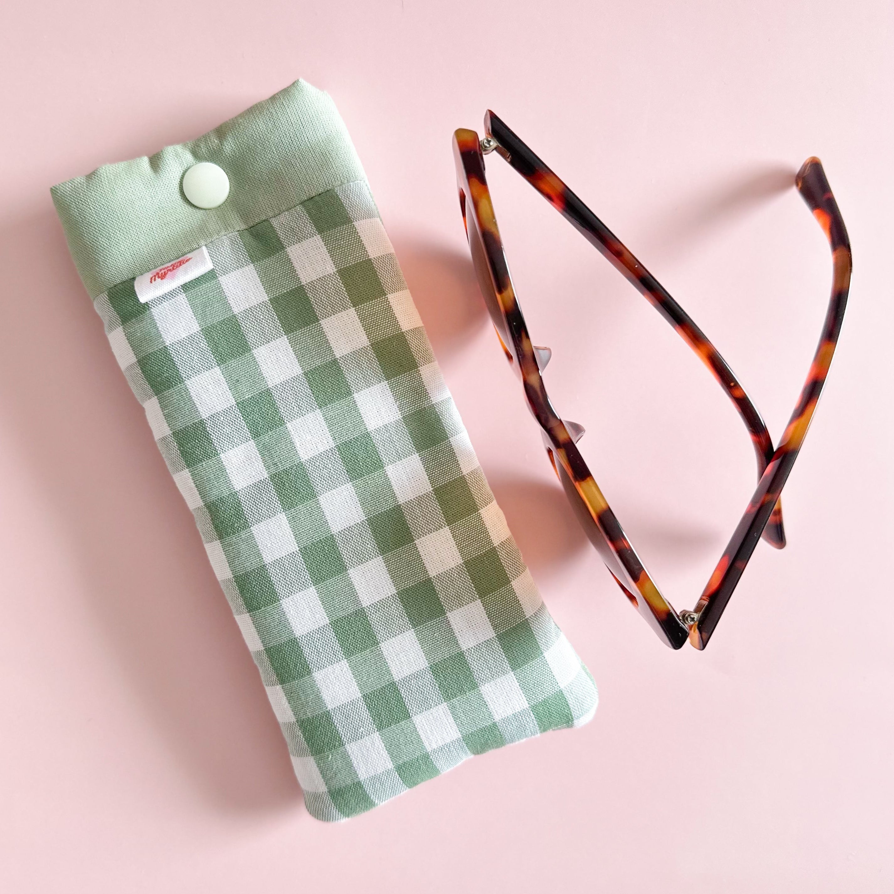 Etuis à lunettes vichy vert sauge cousu main avec lunettes de soleil fond rose clair