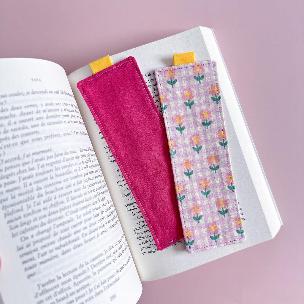 Recto et verso du marque-page en tissu montrant le côté vichy fleuri et le dos en tissu rose fuchsia entièrement cousu main.