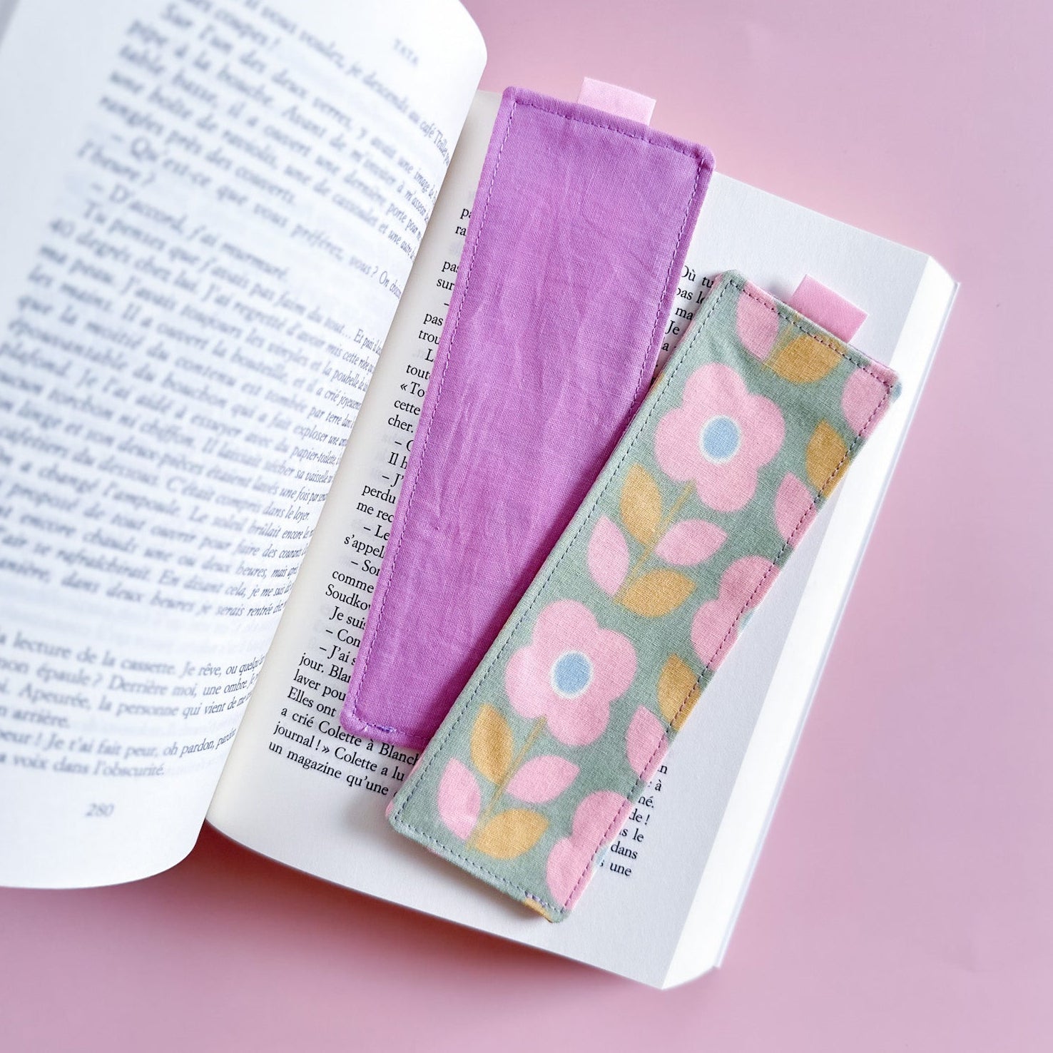 Recto et verso du marque-page en tissu, montrant le côté fleuri et le dos en tissu uni violet mauve avec le petit ruban de coton.