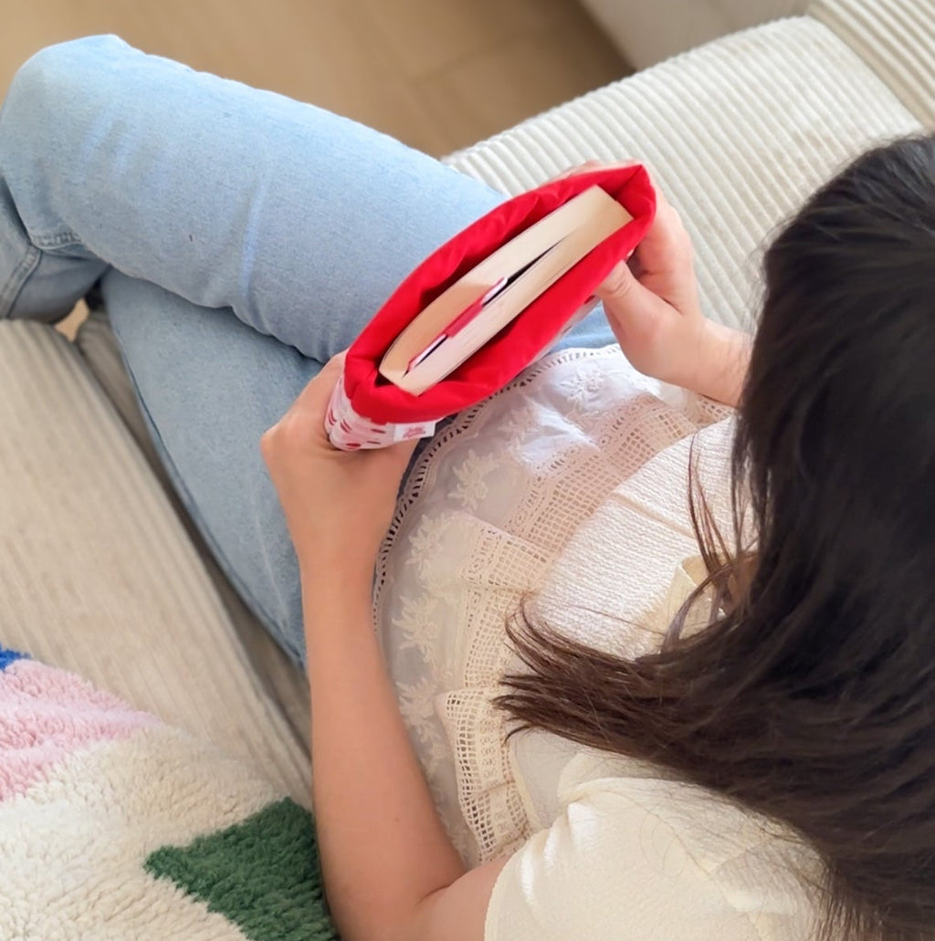 Femme tenant la pochette à livre dans ses main zoom sur l'interieur de la pochette molletonnée 