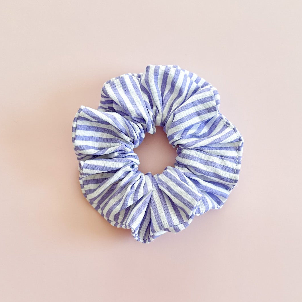 Chouchou pour cheveux à rayures bleues et blanches de fabrication artisanale, présenté à plat.