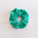 Chouchou cheveux Siena en gaze de coton à rayures vertes et bleu turquoise, de fabrication artisanale, présenté à plat.
