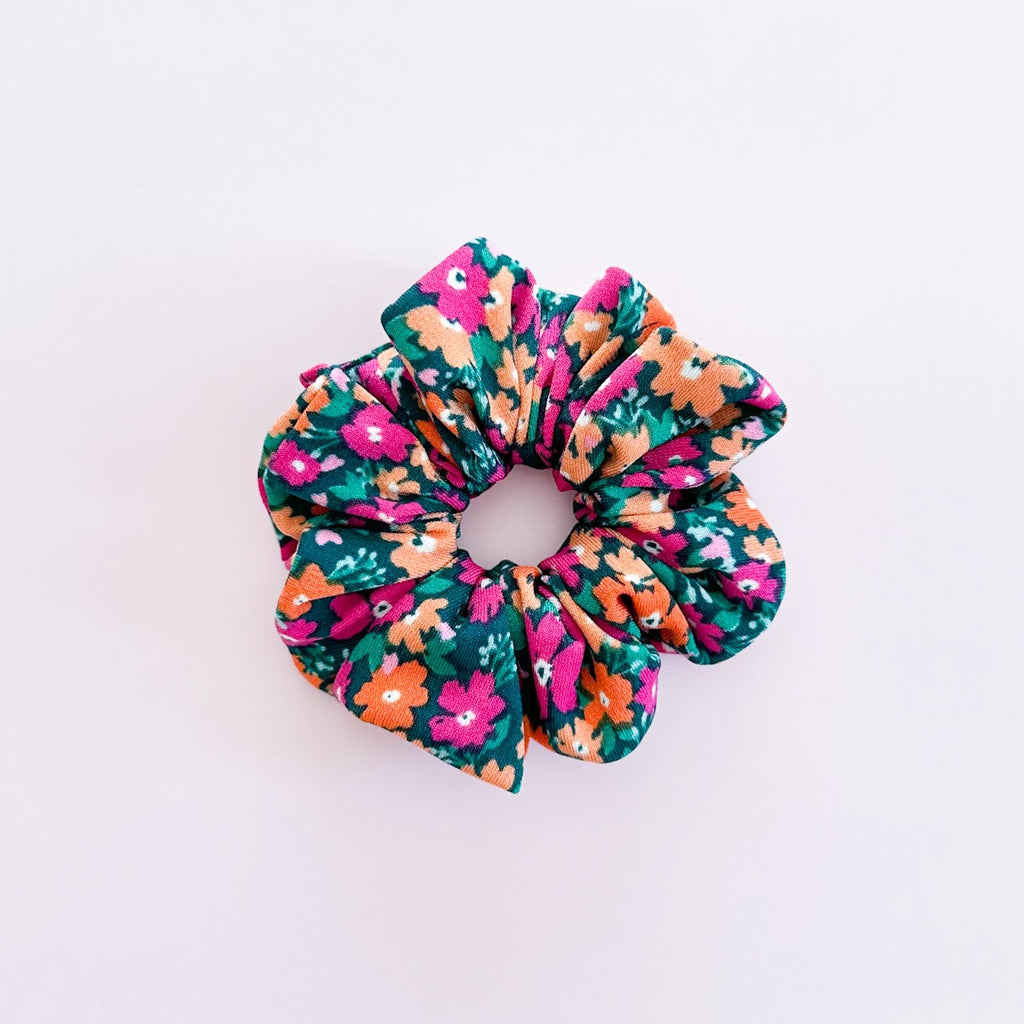 Chouchou cheveux Daisy en jersey extensible à motif de petites marguerites, accessoire femme de fabrication artisanale présenté à plat.