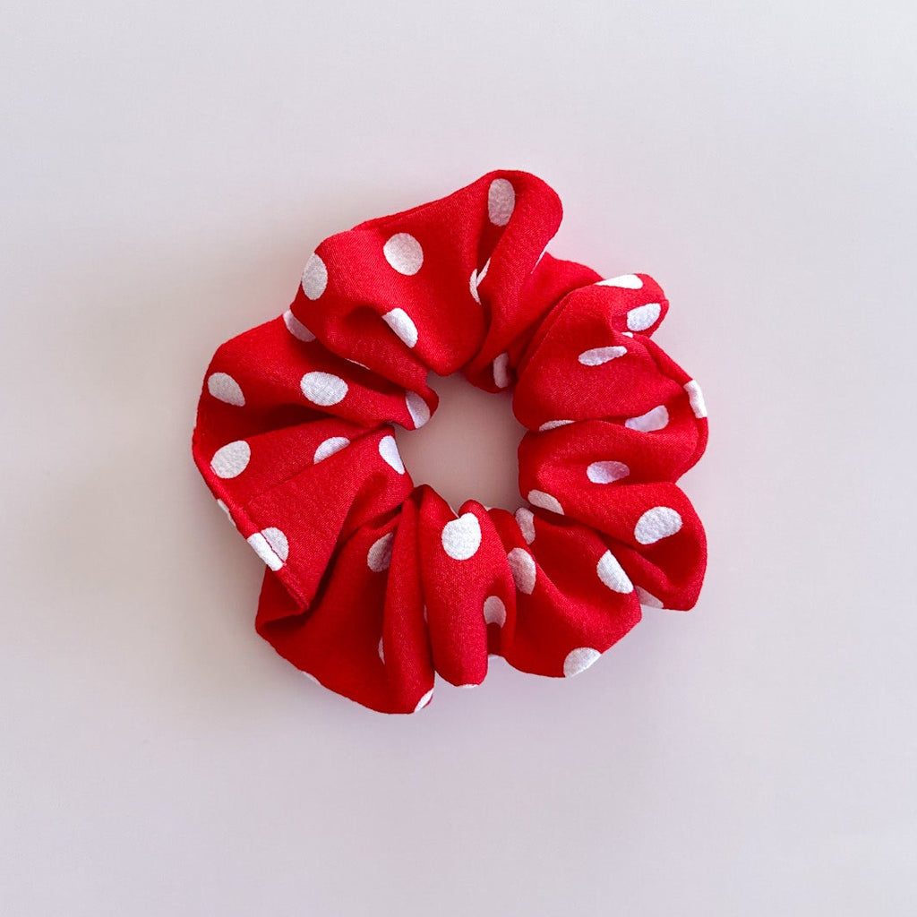 Gros chouchou cheveux Paloma rouge à pois blancs, accessoire femme de fabrication artisanale présenté à plat.