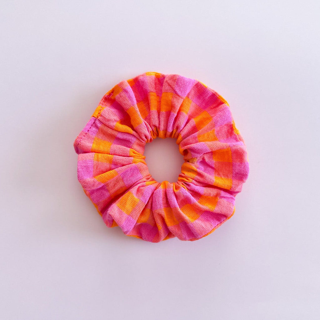 Gros chouchou cheveux vichy rose et orange Suzie de fabrication artisanale, accessoire femme coloré de la marque Jolie Myrtille présenté à plat.