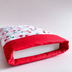 Gros plan sur l'ouverture d'un protège livre montrant sa doublure en coton rouge et son rembourrage molletonné pour protéger les romans des chocs.