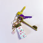 Porte-clés Anita en tissu fleuri accroché à un trousseau de clés, utilisé comme un grigri de sac coloré et pratique.