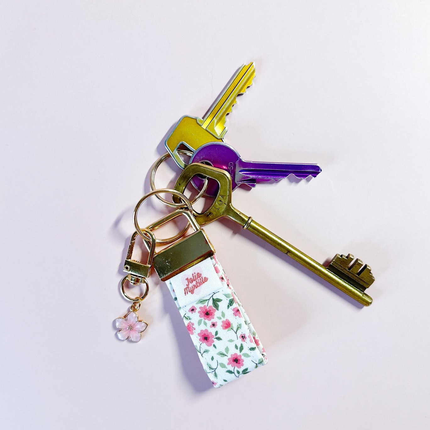 Porte-clés Anita en tissu fleuri accroché à un trousseau de clés, utilisé comme un grigri de sac coloré et pratique.