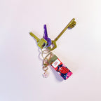 orte-clés Charlotte en tissu fleuri et fruité accroché à un trousseau de clés, utilisé comme un grigri de sac coloré et pratique au quotidien.