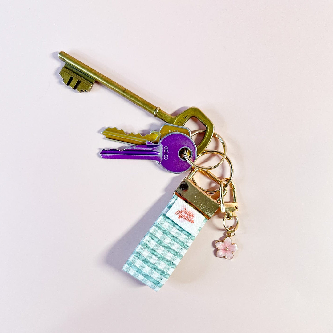 Porte-clés Matcha en tissu vichy vert accroché à un trousseau de clés, utilisé comme un grigri de sac coloré et pratique.