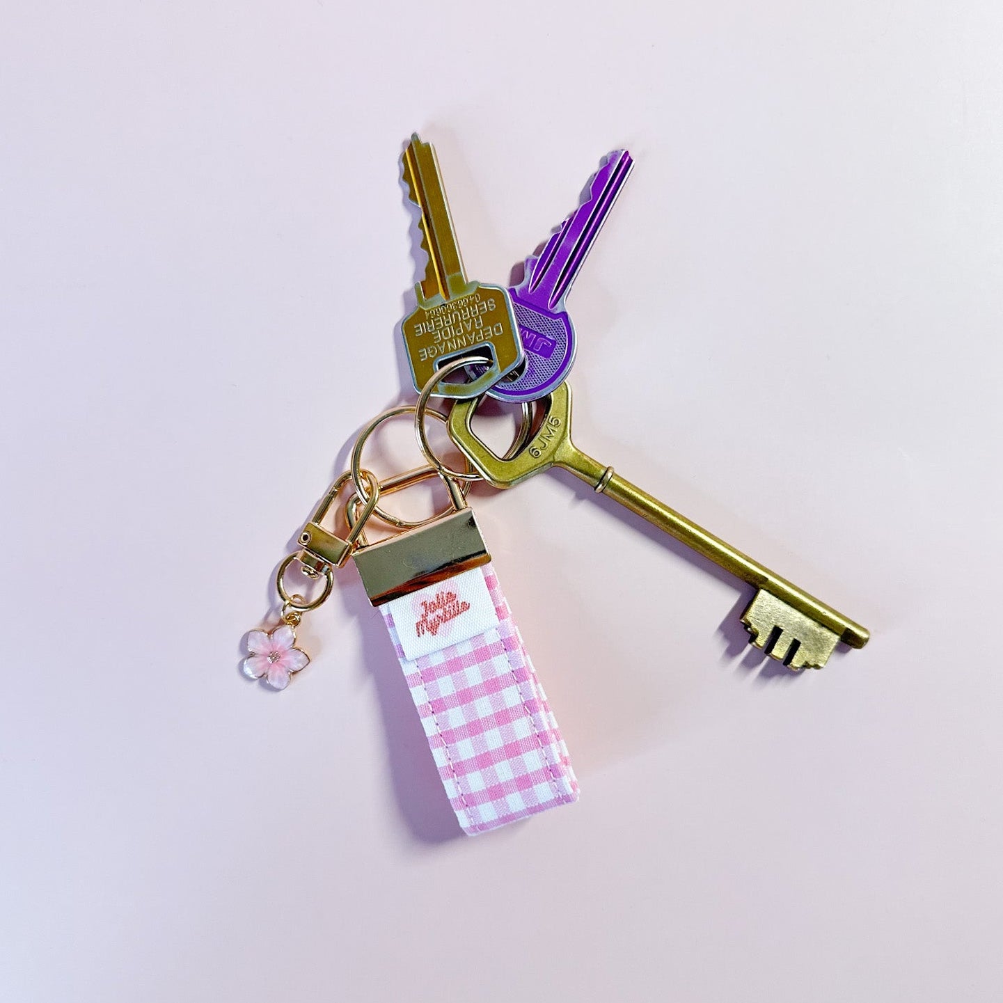 Porte-clés Rosie en tissu vichy rose accroché à un trousseau de clés, utilisé comme un grigri de sac coloré et pratique au quotidien.