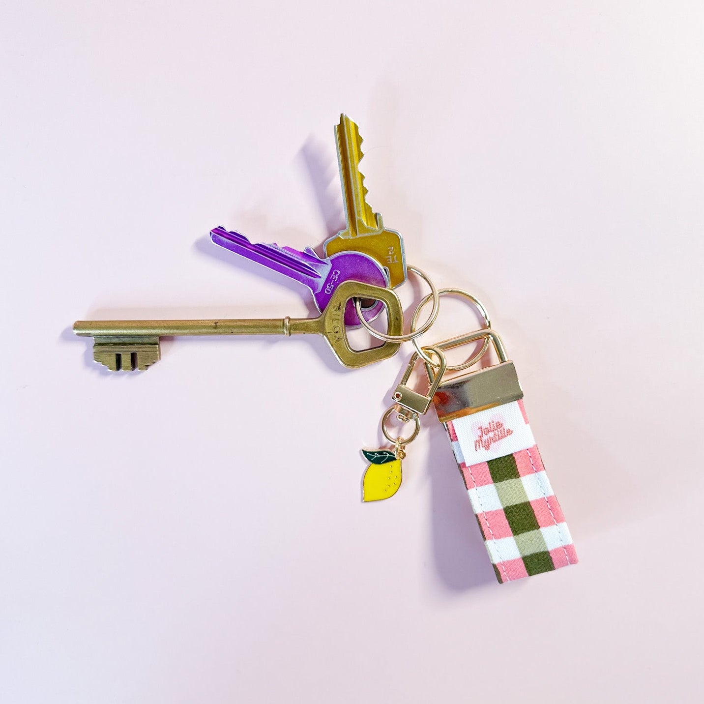 Porte-clés Zita en tissu vichy rose et kaki accroché à un trousseau de clés, utilisé comme un grigri de sac original et pratique au quotidien
